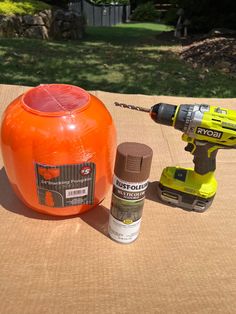 an orange object sitting on top of a table next to a drill and glue bottle