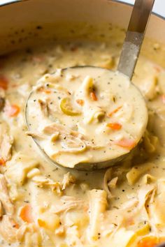 creamy chicken noodle soup in a white bowl with a ladle