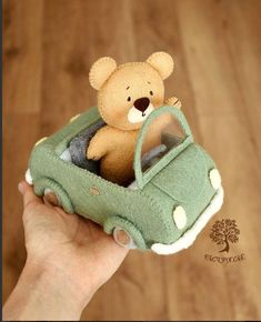 a teddy bear is sitting in the back of a green car