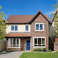 a two story brick house with white windows and blue door in front of grass area