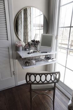 a mirror sitting on top of a white shelf next to a desk with makeup and other items