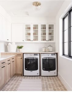 a kitchen with two washers and a dryer in the middle of the room