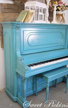 a blue piano sitting in front of a bird cage