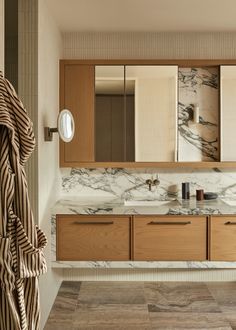 a bathroom with marble counter tops and wooden cabinets