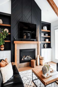 Modern living room with black fireplace wall and wooden accents. Living Room With Black Fireplace Wall, Black Accent Wall Fireplace Living Room, Dark Accent Wall Behind Fireplace, Black Wood Slat Fireplace, Midcentury Modern Fireplace Wall, Black Mantle Fireplace Painted, Accent Wall Over Fireplace, Off Set Fireplace Living Room, Black Wall Fireplace Ideas