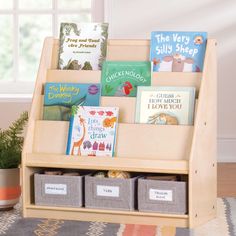 children's books and toys are arranged in a wooden book stand with bins