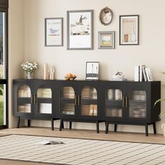 a living room with pictures on the wall and an area rug in front of it