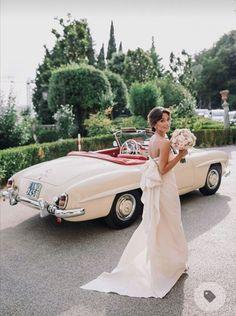 a woman in a wedding dress standing next to a car