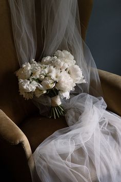 a bouquet of white flowers sitting on top of a chair