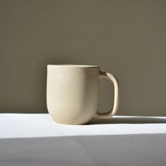 a white cup sitting on top of a table