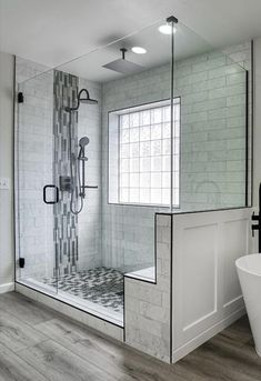 a bathroom with a glass shower door and white tub in the corner next to it