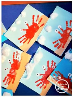 four handprints with clouds and eyes on them are displayed in front of blue paper