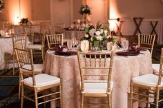 the tables are set up with white linens and gold chairs for guests to sit at