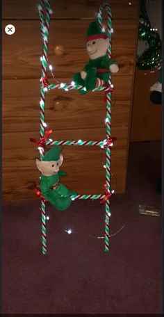 two elfs on a ladder made out of candy canes