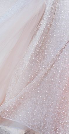 the back of a wedding dress with white pearls on it, and a long train