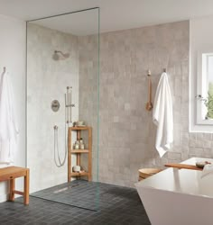 a bathroom with a walk in shower next to a white bath tub and wooden stools