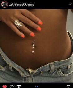 a woman's stomach with orange and white nail polish on her nails, showing the bottom part of her belly