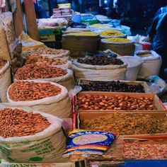 many bags of nuts are on display at the market