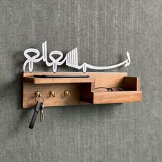 a wooden shelf with a key holder and some keys hanging on the wall next to it