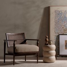 a living room with a chair and art on the wall, next to a painting