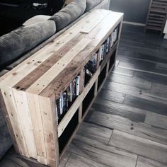 a couch sitting next to a wooden shelf filled with books