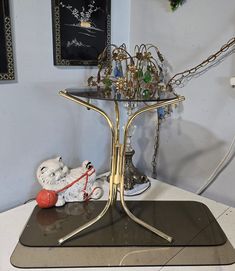 a table that has some kind of jewelry on it with chains hanging from the top