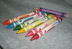 five crayons are lined up on the bed