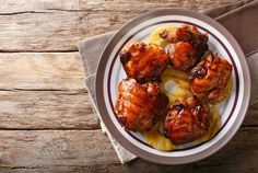 some food is on a white plate with brown napkins and a wooden table top