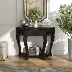 a living room scene with focus on the end table and vases, books, and plants