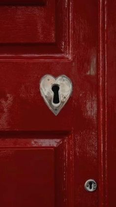 a red door with a heart shaped lock on it's side and a keyhole in the middle