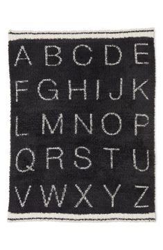 a black rug with white letters and numbers on the front, in an alphabet pattern