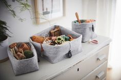 three bins filled with assorted items on top of a white counter