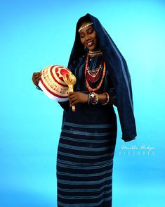 A model is wearing a Fulani Bridal outfit which is a long sleeve blouse, wrapper, head scarf and veil.She is also carrying a Calabash Fulani Traditional Clothes, Fulani Clothes, Fulani Styles, Hausa Fashion, Fulani Culture, Fulani Wedding, Hausa Bride, Hausa Wedding, African Aesthetic