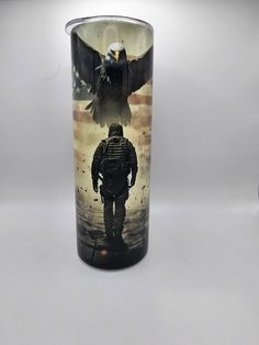 a shot glass with the image of an eagle and a soldier on it is shown