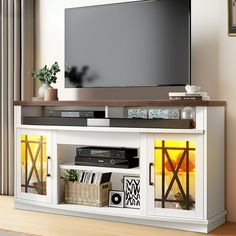 a flat screen tv sitting on top of a white entertainment center