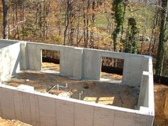 an unfinished concrete house in the woods