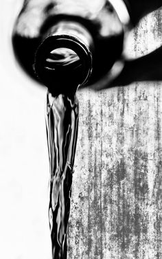 a black and white photo of a faucet with water running down it's side