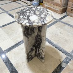 a marble table sitting on top of a tiled floor