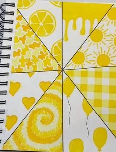 a spiral notebook with yellow and white designs on it's cover, which has lemons in the center