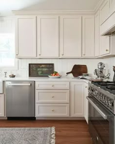 a kitchen with white cabinets and stainless steel appliances