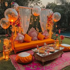 an orange couch sitting on top of a lush green field next to a swimming pool