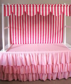 pink and white striped canopy bed with ruffled bedskirt on the bottom bunk