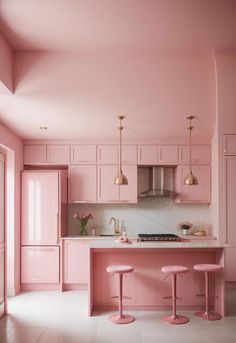 a kitchen with pink walls and stools