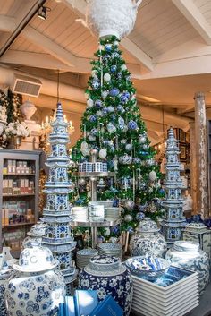 a blue and white christmas tree in a store with other items on display behind it