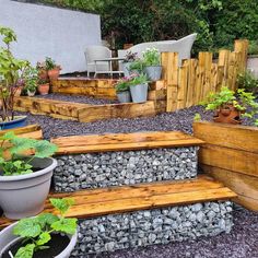 some plants are growing on the steps in this backyard garden with gravel and wood planters