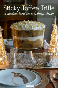 a cake sitting on top of a white plate next to silver plates and christmas trees