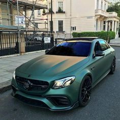 a green mercedes cla parked on the street