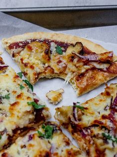 the pizza is cut into four pieces and sits on top of a piece of parchment paper