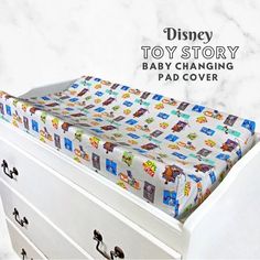 a toy story changing pad cover with cars and trucks on it, sitting on top of a dresser