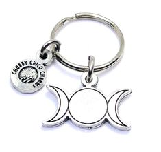 a metal key chain with two moon charms on it